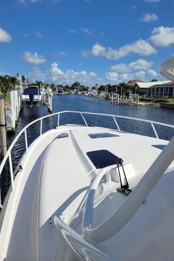  Yacht Photos Pics 2016 Intrepid 475 Sport Yacht cruising in a sunny marina with clear blue skies.