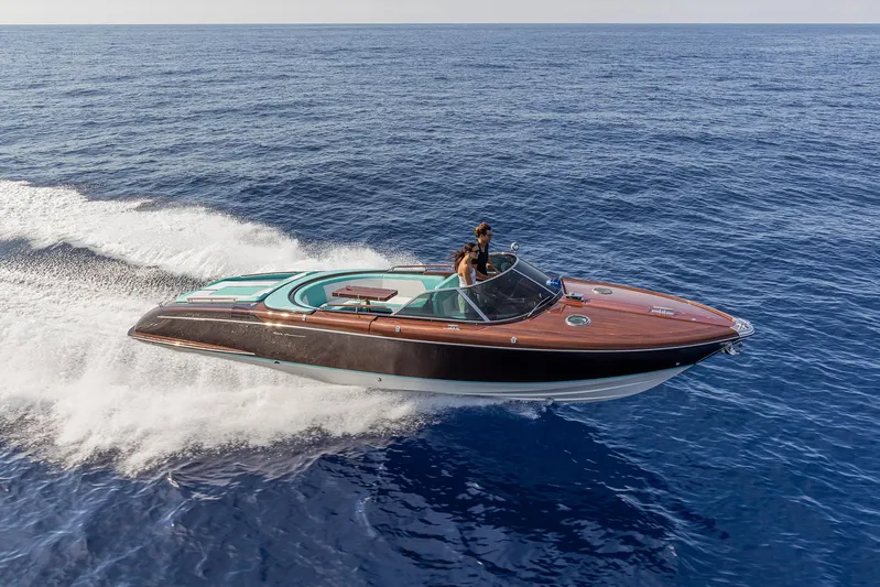 Bacio Yacht Photos Pics 2023 Riva Anniversario speedboat cruising on open sea, showcasing sleek design and luxury.