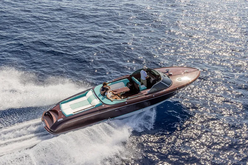Bacio Yacht Photos Pics 2023 Riva Anniversario luxury boat cruising on sparkling blue water.