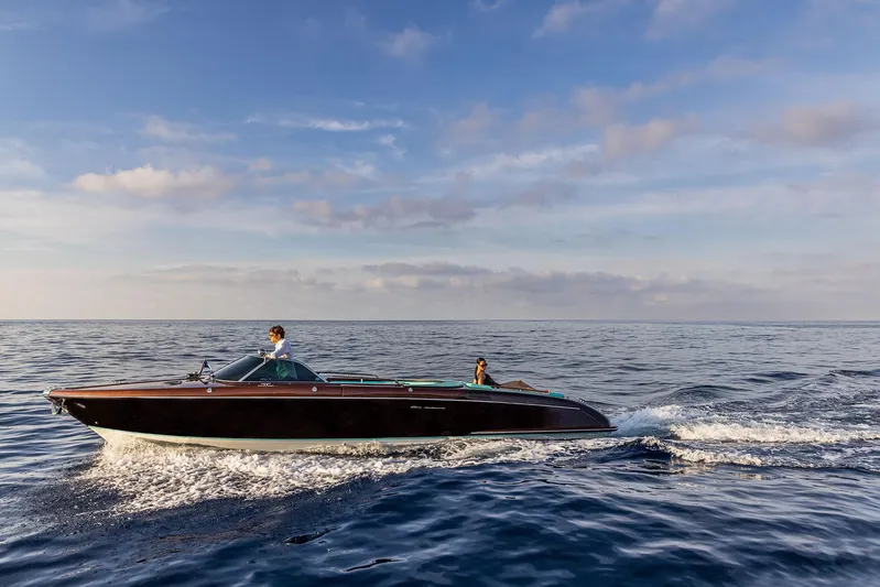 Bacio Yacht Photos Pics 2023 Riva Anniversario boat cruising on open sea under blue sky.