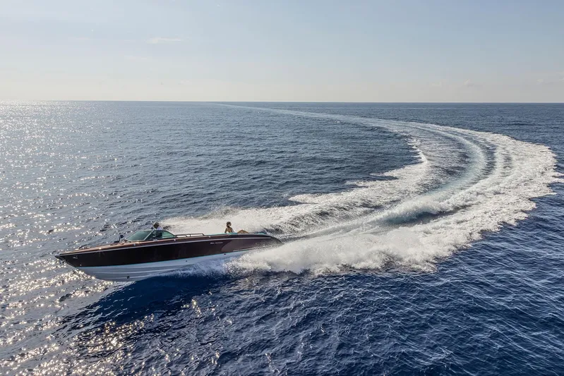 Bacio Yacht Photos Pics 2023 Riva Anniversario yacht cruising on open sea, leaving a dynamic wake trail.