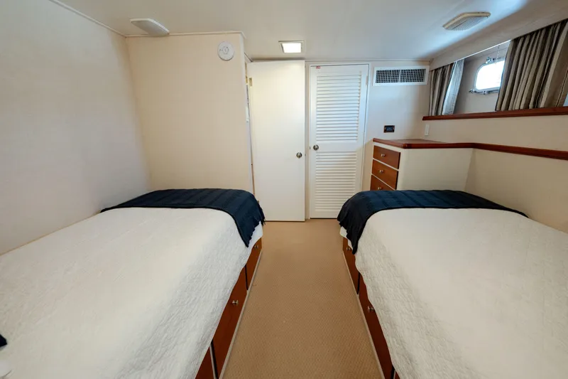 Nordic Star Yacht Photos Pics Twin cabin interior of 1969 Custom Hargrave yacht with white bedding and wood accents.