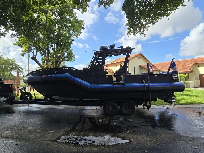 Dgs777 Yacht Photos Pics 2022 DGS 777 Military Version boat on trailer, parked under trees, sunny day.