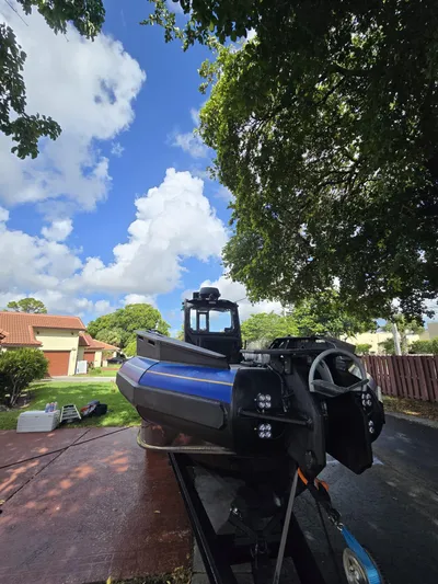 Dgs777 Yacht Photos Pics 2022 DGS 777 Military Version boat on trailer under tree, clear sky background.