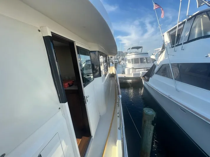 Reflections Yacht Photos Pics Side view of a 1993 Hatteras 60 ED yacht docked at a marina.