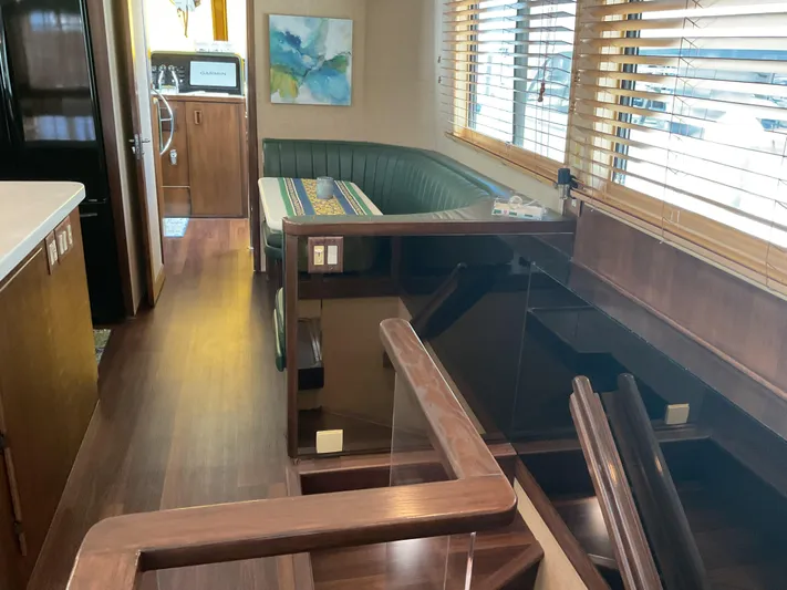Reflections Yacht Photos Pics Interior of 1993 Hatteras 60 ED yacht with wood finishes and green seating area.