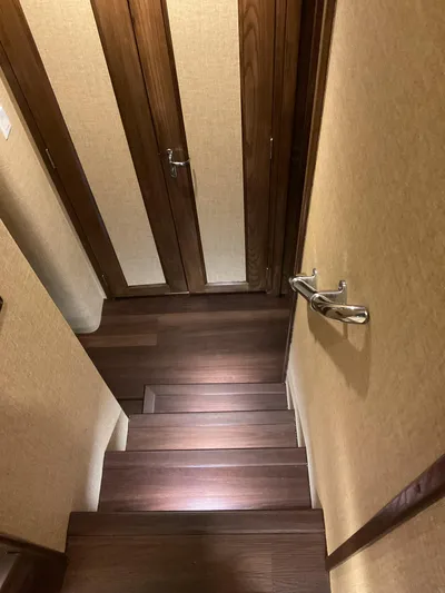 Reflections Yacht Photos Pics Staircase with wooden steps and doors inside a 1993 Hatteras 60 ED yacht.