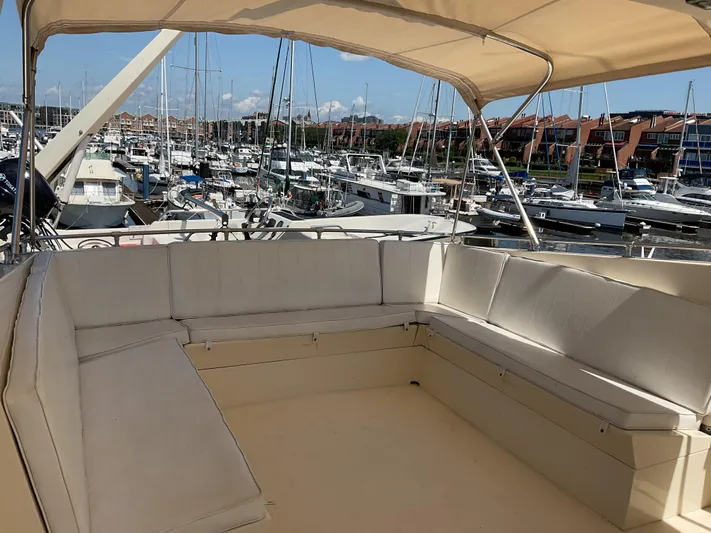 Reflections Yacht Photos Pics 1993 Hatteras 60 ED yacht with spacious seating area, docked in a marina.