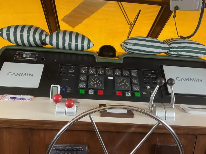Reflections Yacht Photos Pics Helm of 1993 Hatteras 60 ED yacht with Garmin navigation systems and striped cushions.