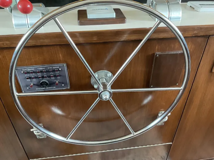 Reflections Yacht Photos Pics Steering wheel of a 1993 Hatteras 60 ED yacht with control panel and wooden dashboard.