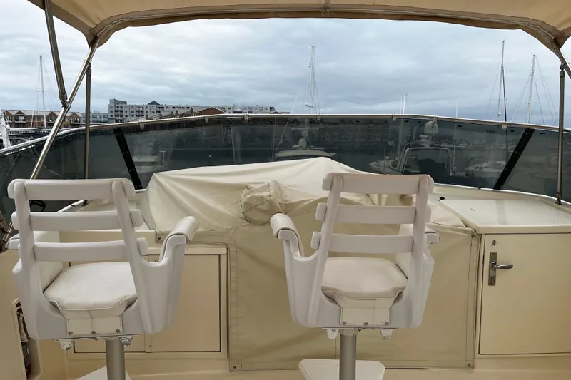 Reflections Yacht Photos Pics 1993 Hatteras 60 ED yacht deck with two white chairs and covered equipment.