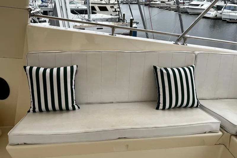 Reflections Yacht Photos Pics White cushioned seating with striped pillows on a 1993 Hatteras 60 ED yacht.