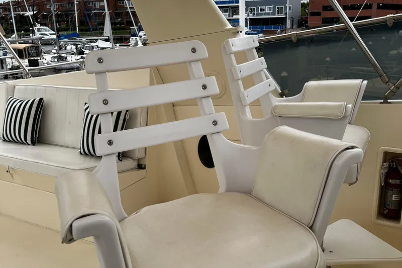 Reflections Yacht Photos Pics Luxury seating on 1993 Hatteras 60 ED yacht with striped cushions and marina view.