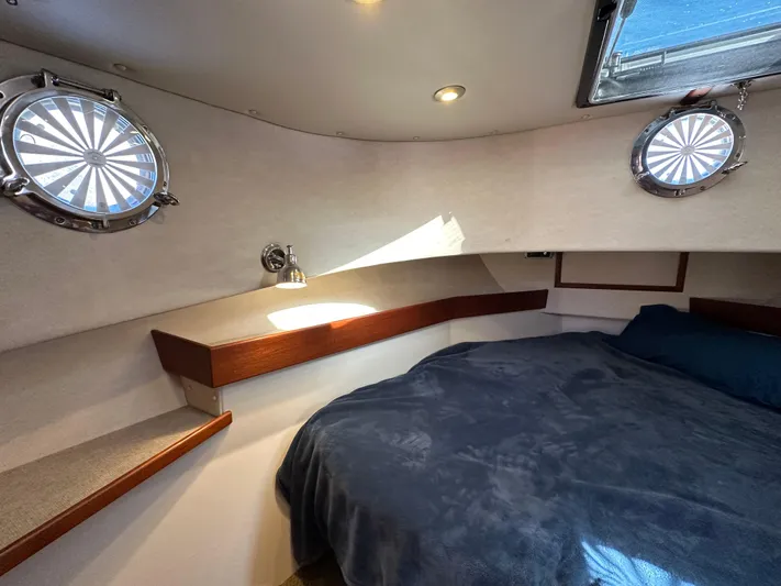  Yacht Photos Pics Cozy cabin interior of 2007 Nordic Tug 32 with portholes and bed.