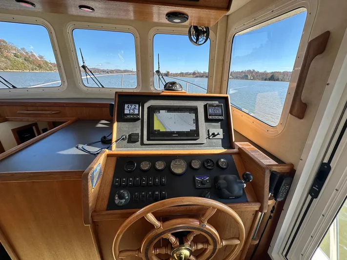  Yacht Photos Pics 2007 Nordic Tug 32 helm with navigation equipment and scenic water view.