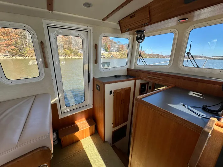  Yacht Photos Pics Interior of 2007 Nordic Tug 32 with wood finish and scenic water view.