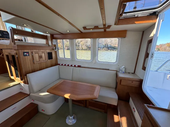  Yacht Photos Pics Cozy interior of 2007 Nordic Tug 32 with wood accents and river view.
