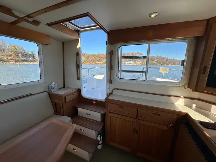  Yacht Photos Pics Interior of 2007 Nordic Tug 32 with wooden cabinetry and river view.
