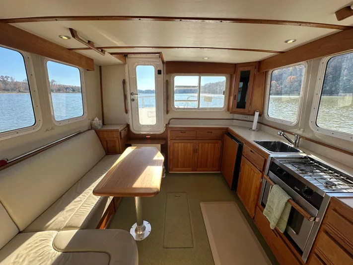  Yacht Photos Pics Interior of 2007 Nordic Tug 32 with kitchen and seating area, overlooking water.