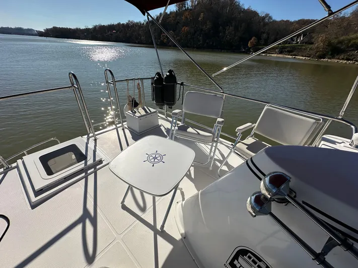  Yacht Photos Pics 2007 Nordic Tug 32 boat deck with chairs and table on a sunny day.
