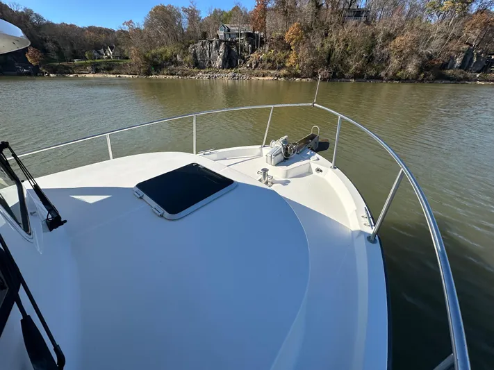  Yacht Photos Pics 2007 Nordic Tug 32 on calm river, surrounded by autumn trees.