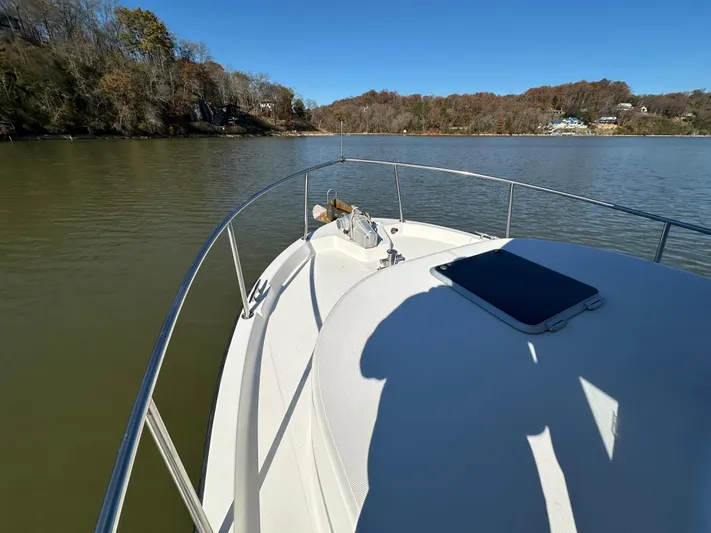  Yacht Photos Pics Nordic Tug 32 (2007) cruising on a calm lake with scenic shoreline.