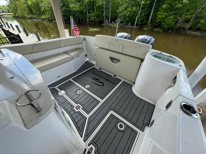 Mullin' It Over Again Yacht Photos Pics 2019 Regal 33 SAV boat interior with seating and American flag, docked by a river.