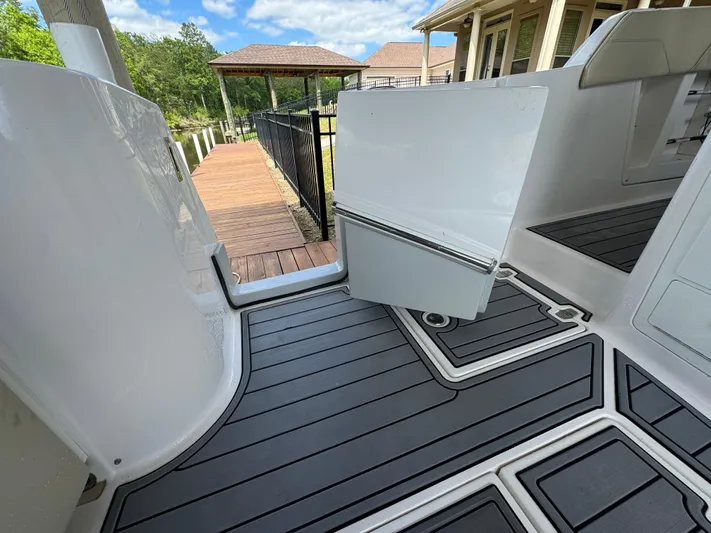 Mullin' It Over Again Yacht Photos Pics 2019 Regal 33 SAV boat deck with open hatch, near wooden dock and house.