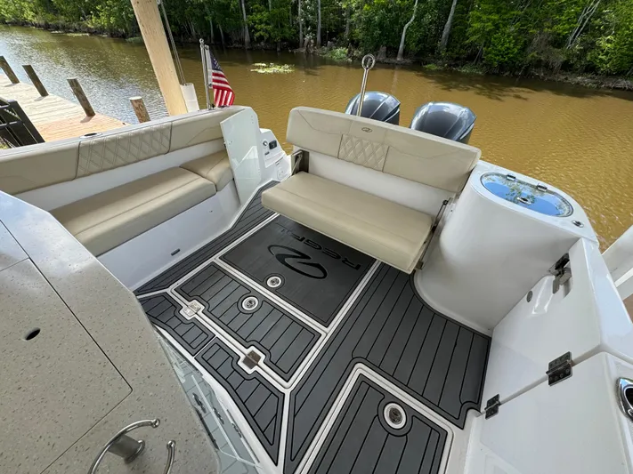 Mullin' It Over Again Yacht Photos Pics 2019 Regal 33 SAV boat interior with seating and deck, docked by a river.