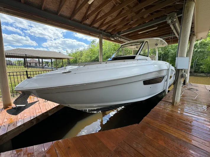 Mullin' It Over Again Yacht Photos Pics 2019 Regal 33 SAV boat docked under wooden shelter on a sunny day.