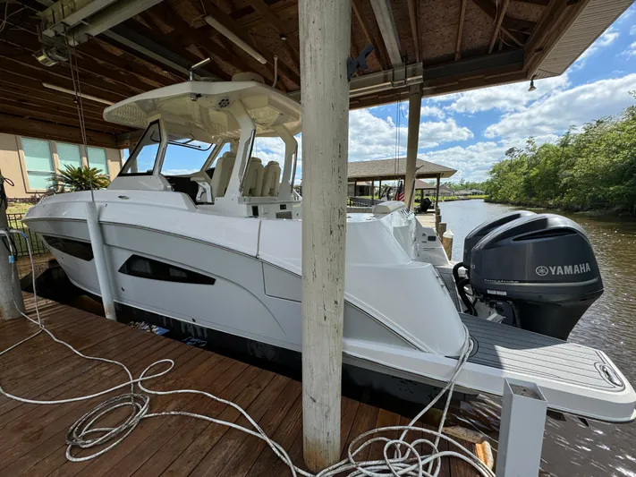 Mullin' It Over Again Yacht Photos Pics 2019 Regal 33 SAV boat docked with Yamaha engine, under a wooden canopy.
