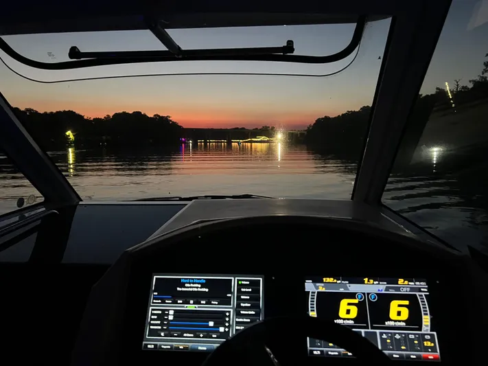 Mullin' It Over Again Yacht Photos Pics Cockpit view from a 2019 Regal 33 SAV boat at sunset on a calm river.