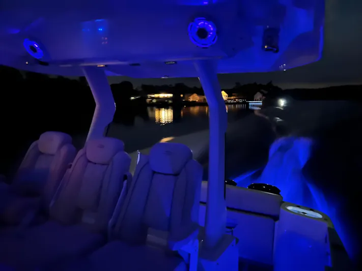 Mullin' It Over Again Yacht Photos Pics 2019 Regal 33 SAV boat interior with blue LED lighting at night on a calm lake.