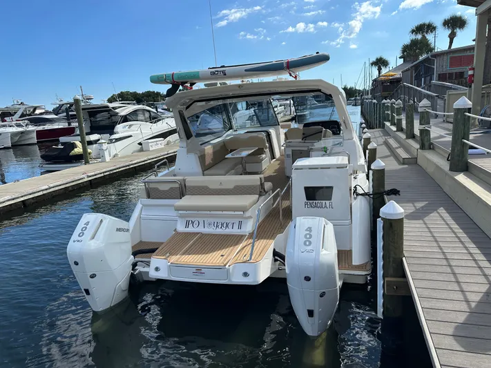  Yacht Photos Pics 2025 Aquila 36 Sport boat docked, featuring twin Mercury 400 engines, in a marina setting.