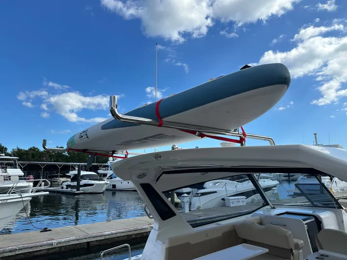  Yacht Photos Pics 2025 Aquila 36 Sport with paddleboard on roof, docked at marina under blue sky.