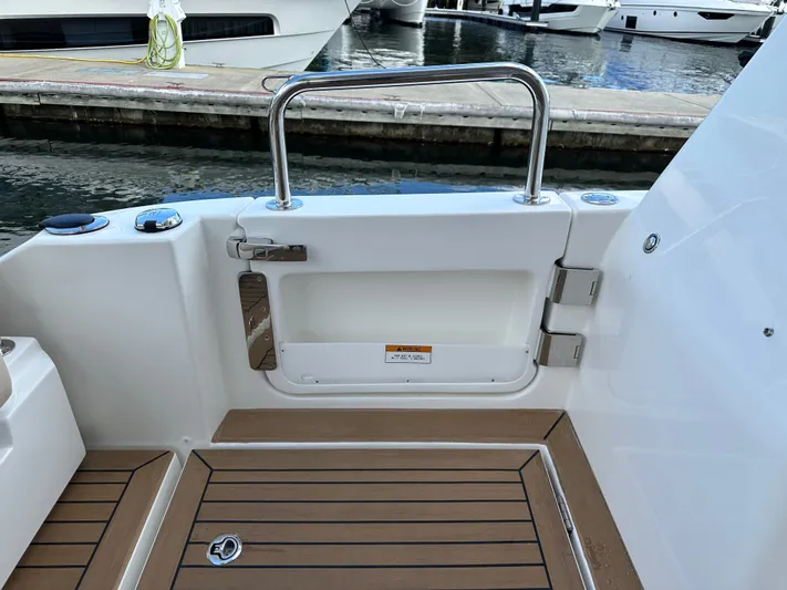  Yacht Photos Pics Aquila 36 Sport 2025 boat deck with teak flooring and stainless steel railing.