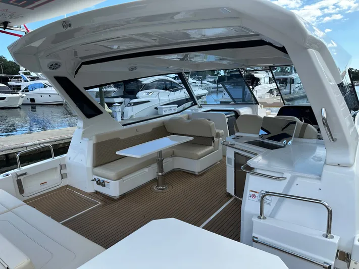  Yacht Photos Pics 2025 Aquila 36 Sport yacht interior with seating and table, docked at marina.