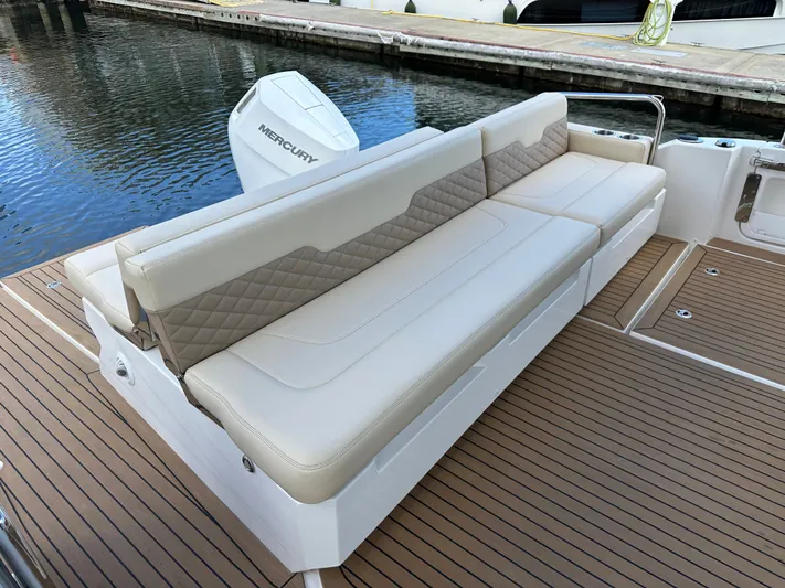  Yacht Photos Pics Luxury seating on 2025 Aquila 36 Sport boat with Mercury engine, docked by the water.