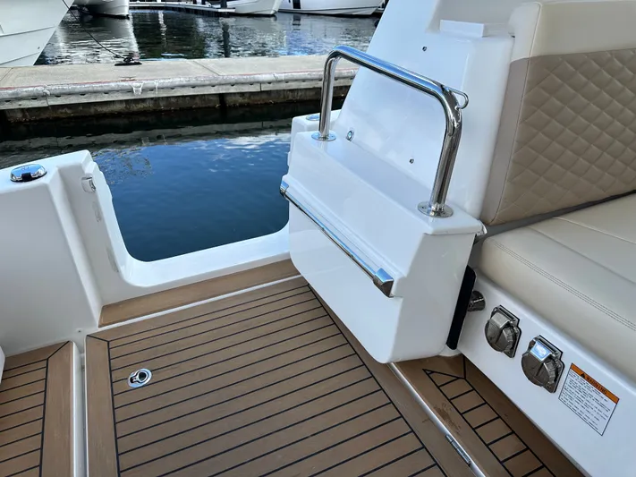  Yacht Photos Pics Aquila 36 Sport 2025 boat interior with teak flooring and cushioned seating.