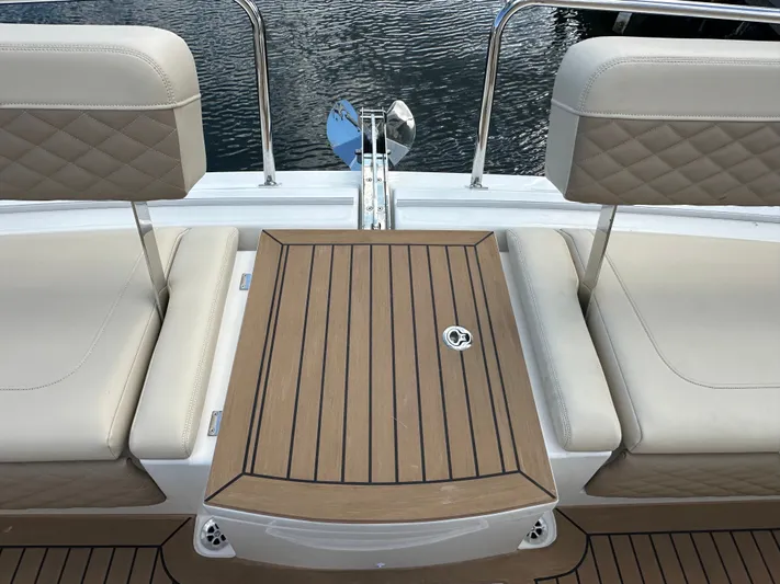  Yacht Photos Pics Aquila 36 Sport 2025 boat seating with wooden table, docked by water.