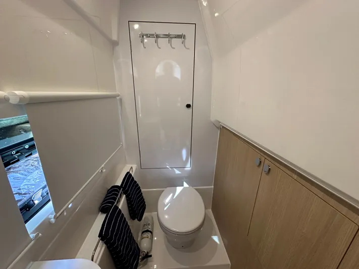  Yacht Photos Pics 2025 Aquila 36 Sport bathroom interior with modern fixtures and wooden cabinetry.