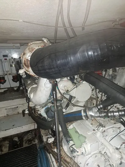  Yacht Photos Pics Engine room of 1999 Hatteras 50 Convertible yacht, showcasing mechanical components and hoses.