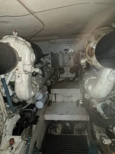  Yacht Photos Pics Engine room of 1999 Hatteras 50 Convertible yacht, showcasing dual engines and mechanical components.