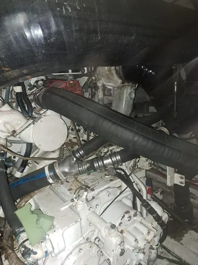  Yacht Photos Pics Engine compartment of a 1999 Hatteras 50 Convertible boat, showcasing hoses and mechanical components.