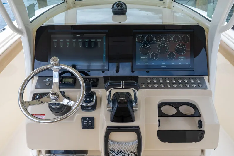 Innisfree Yacht Photos Pics Control panel of 2015 Scout 300 LXF boat with dual screens and steering wheel.