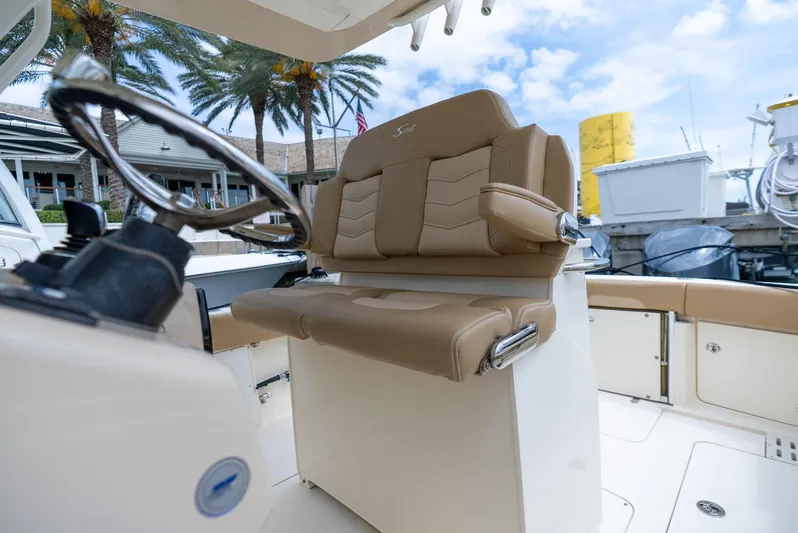 Innisfree Yacht Photos Pics 2015 Scout 300 LXF boat interior with tan seating and steering wheel.