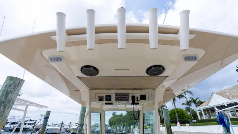 Innisfree Yacht Photos Pics 2015 Scout 300 LXF boat roof with rod holders and speakers at a marina.