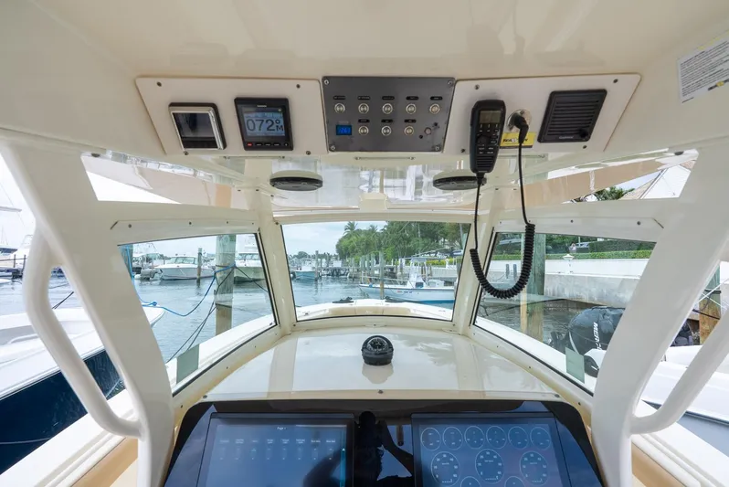 Innisfree Yacht Photos Pics Interior view of 2015 Scout 300 LXF boat cockpit with control panel and marina background.