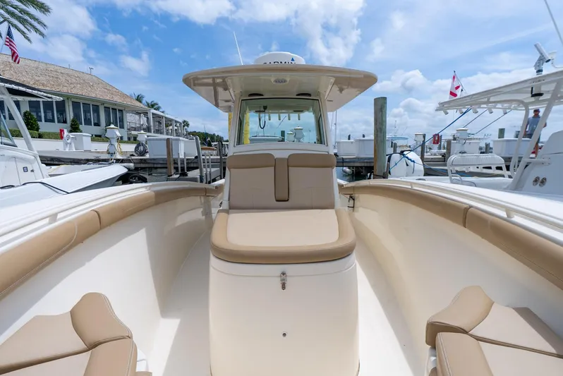 Innisfree Yacht Photos Pics 2015 Scout 300 LXF boat with beige seating, docked at a marina under a blue sky.