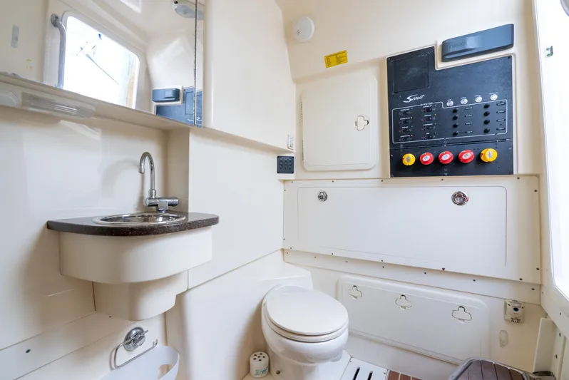 Innisfree Yacht Photos Pics Interior of 2015 Scout 300 LXF boat bathroom with sink, toilet, and control panel.